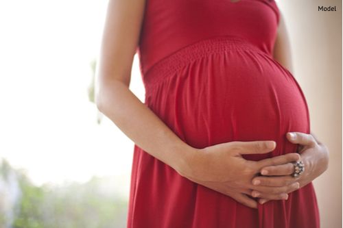 Pregnant mother cradling her stomach.